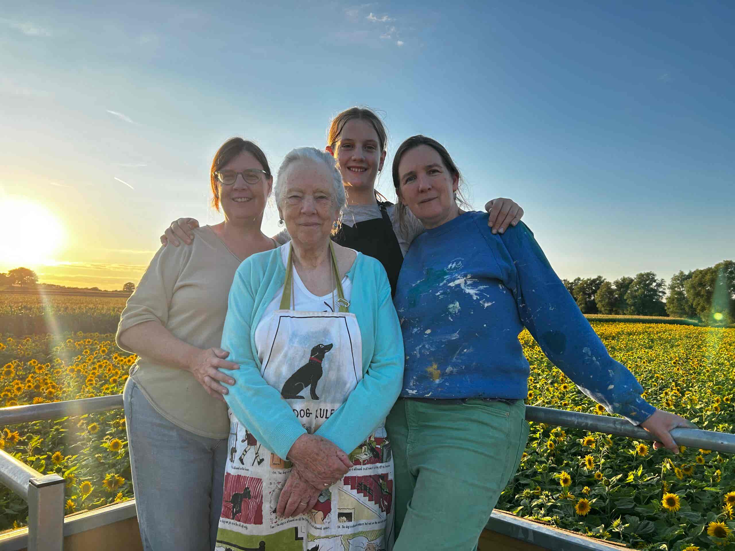 happy artists on top of the viewing platform at Lichfield maize Maze, admiring the sunset and the sunflowers