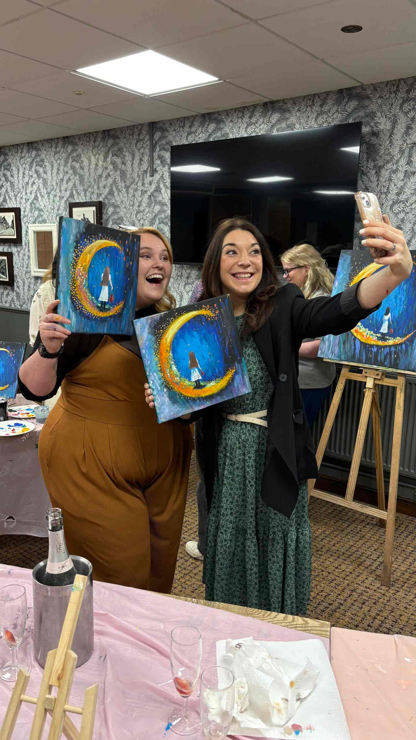 excited customers who are taking a selfie with their paintings